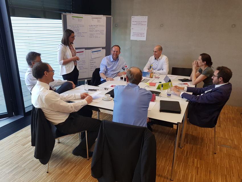 Atelier collaboratif en petit groupe autour d'une table et de flipcharts